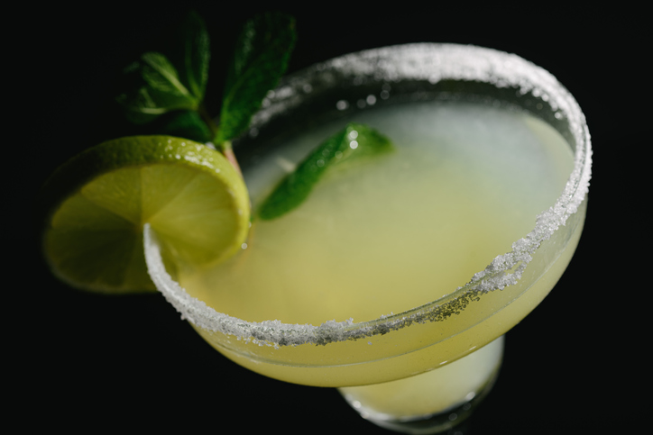 Close-up shot of a margarita cocktail in dim lighting.