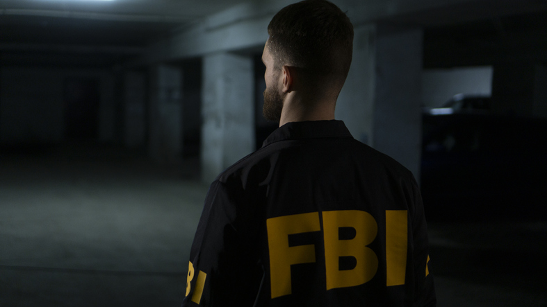 FBI agent from the back in a dark underground parking lot
