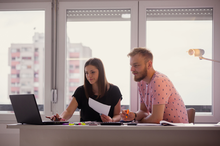 two young people, students working on a project together. lookin