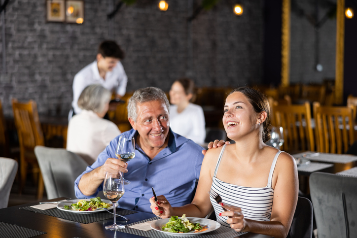 Senior man spending time with young girl in restaurant