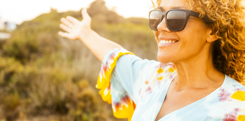 Portrait of happy cheerful woman in outdoor leisure activity alone smiling and enjoying freedom in sunset light time. Travel people. Healthy lifestyle and nature. Adult female happy and free person