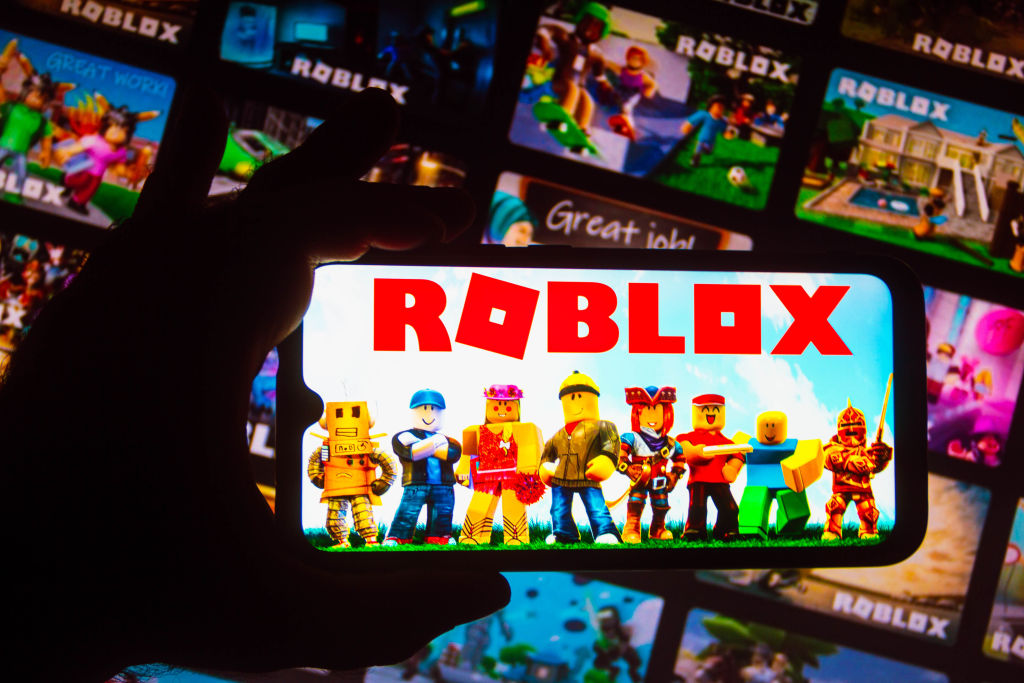 In this photo illustration the Roblox logo seen displayed on...