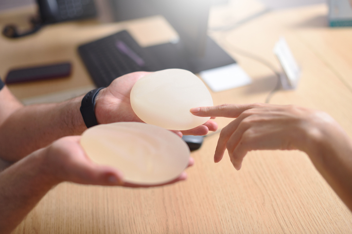 Female hand picks silicone implants for breast augmentation