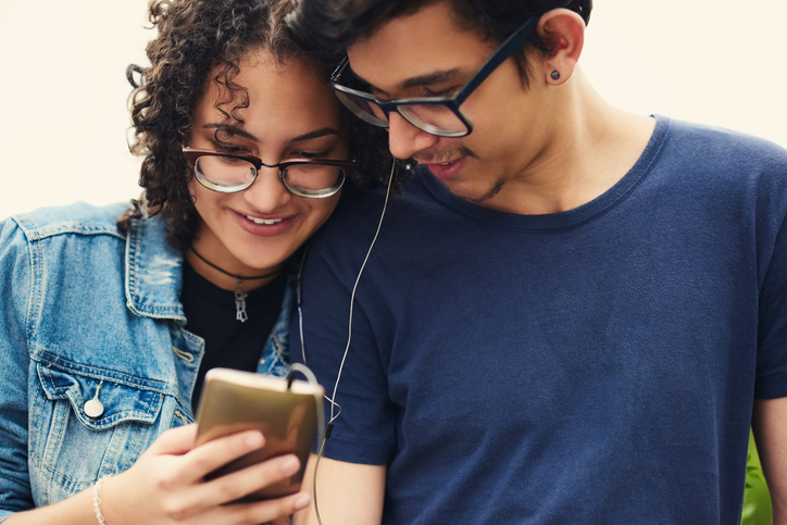 Cropped shot of a teenage couple listening to music together outdoors