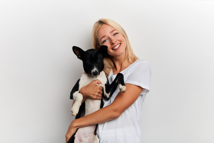 happy young beautiful woman hugging her favourite pet