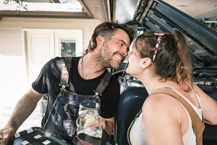 Mid adult English auto mechanic couple working in their garage
