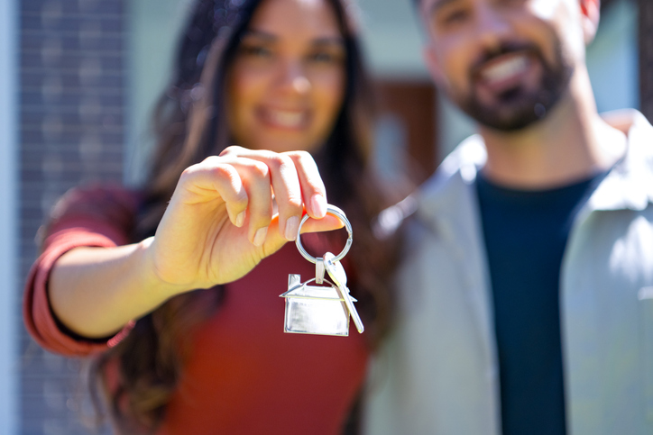 Close up happy woman and man, holding keys from new first house
