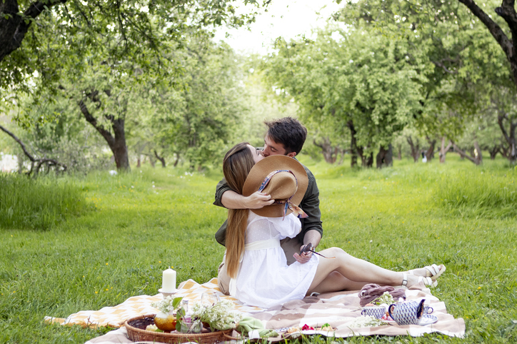 young couple on a picnic in summer park, kissing