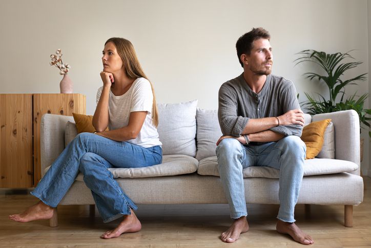 Young couple ignoring each other sitting on the couch. Couple fighting at home.