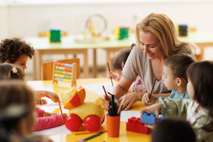 Teacher drawing whit children in kindergarten
