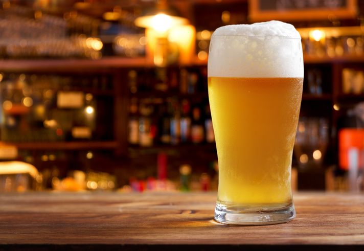 glass of beer in a bar on wooden counter