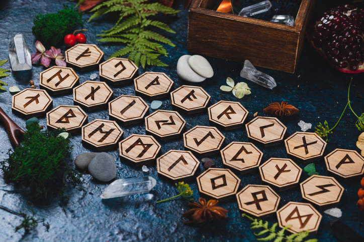 Wooden runes are lying on the table among various objects. Astrology and esotericism. Senior Futhar