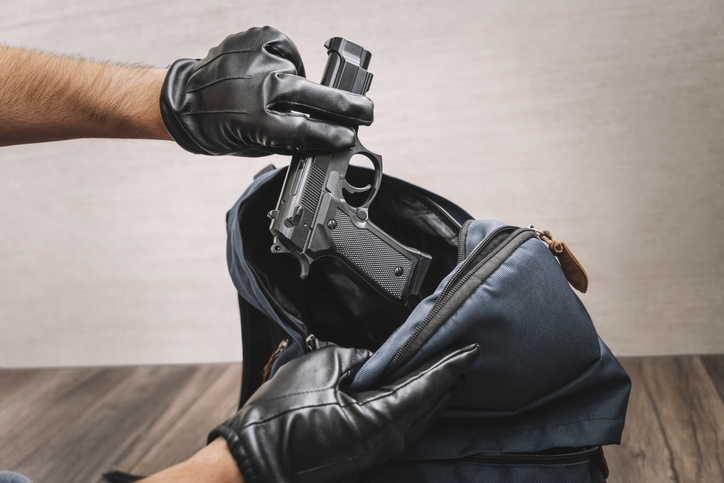 man in gloves takes a gun out of his backpack. Seizure of weapons and baggage search. Crime concept. The policeman searches the bag. evidence of a crime.