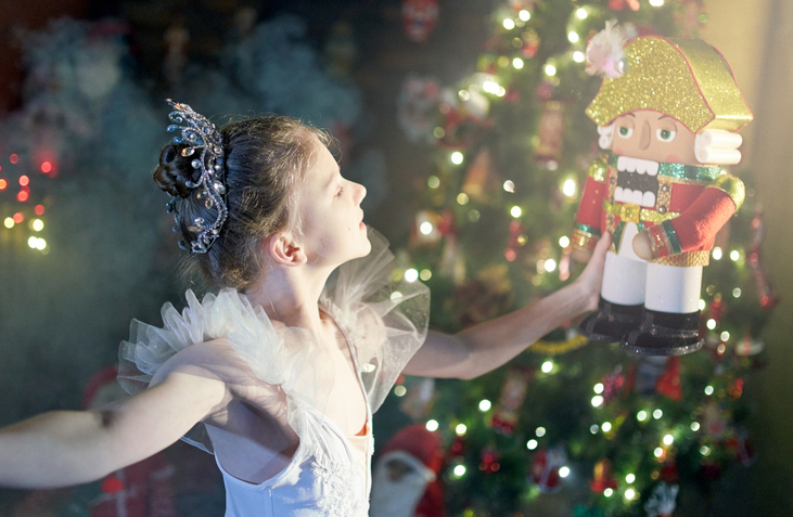 Beautiful preteen girl ballet dancer is holding the Nutcracker on her hands