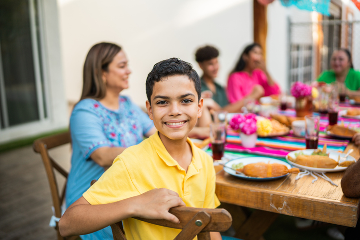 Portrait of child boy during family lunch at house yard