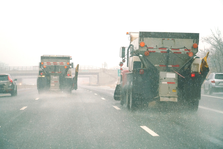 Snowplow spreading salt on the highway