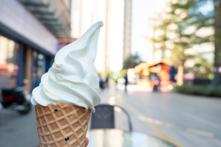 hand holding ice cream cone in the outdoor at horizontal composition