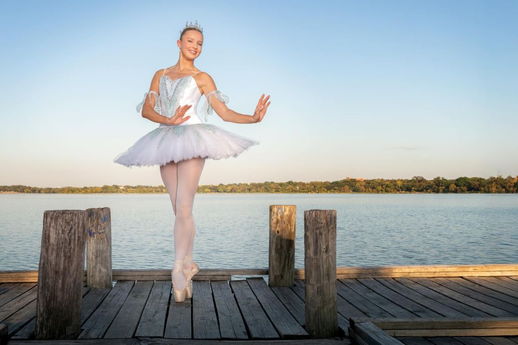 ballet dancer in tutu posing on lakeside dock