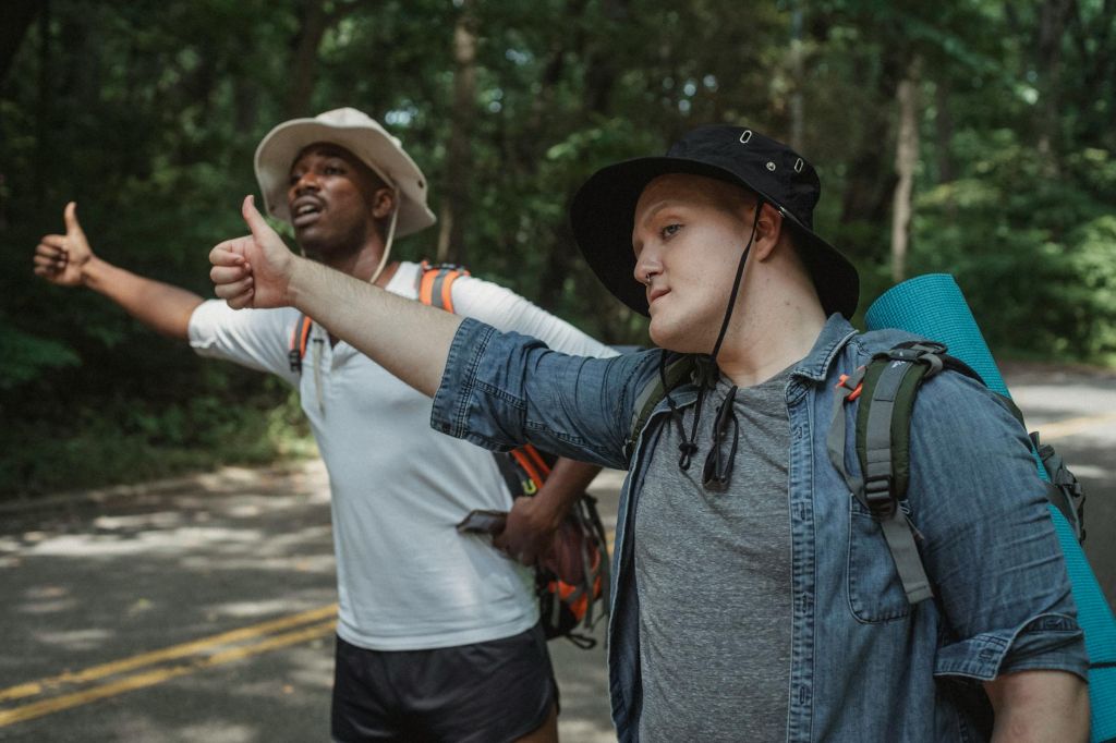 multiethnic hikers voting on countryside roadway during trip