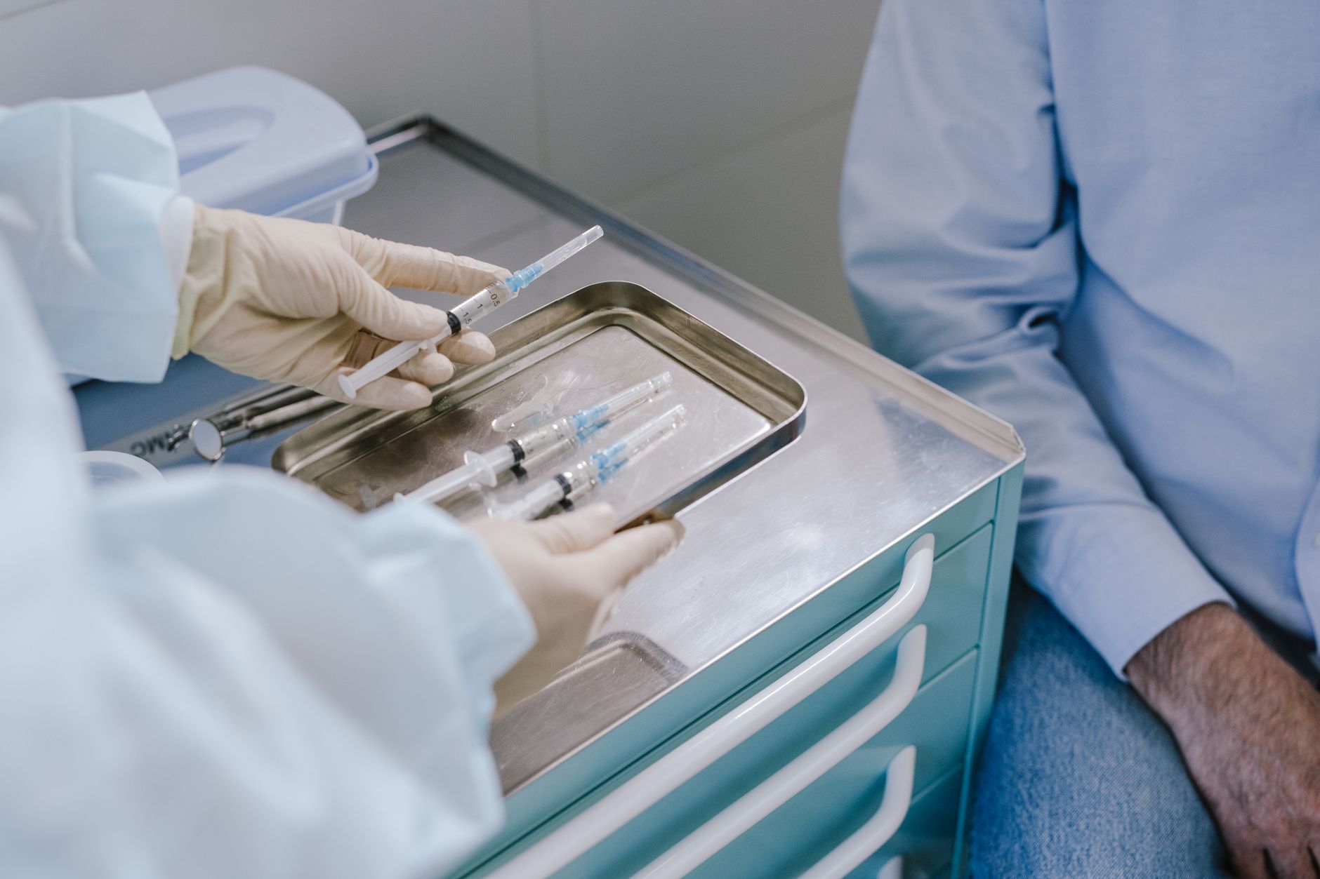 a medical professional holding a tray of syringes